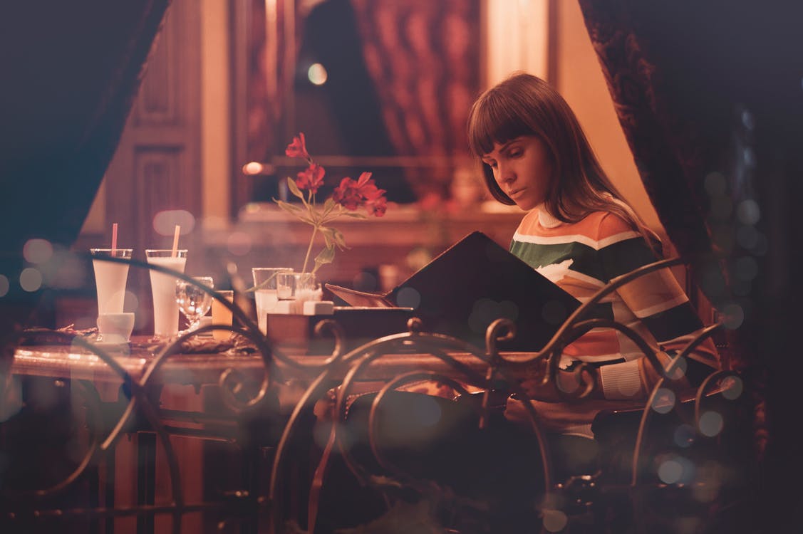 femme à table qui lis un menu